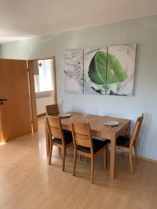 a dining room with a wooden table and chairs at Preiswerte Ferienwohnung in Neukirchen