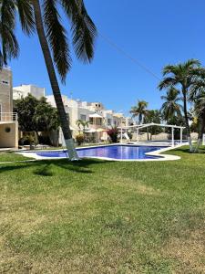 une piscine entourée de palmiers dans un parc dans l'établissement Luxurios house, pool and beach YOUR OASIS, à Acapulco