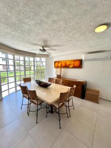 une cuisine avec une table avec des chaises et des oranges sur le mur dans l'établissement Luxurios house, pool and beach YOUR OASIS, à Acapulco