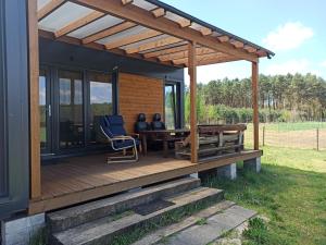 a house with a deck with two people sitting at a table at Chabrowa Polana in Tuplice