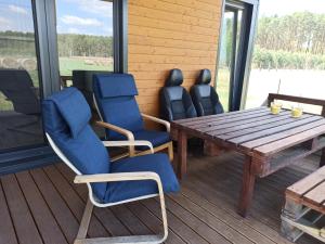 a wooden table and chairs on a deck at Chabrowa Polana in Tuplice +19 photos