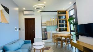 a living room with a blue couch and a table at Gau House in Hai Phong
