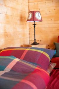 a lamp sitting on a table next to a bed at Glampinghütte Georgenthal in Georgenthal +11 photos