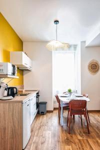 kuchnia ze stołem i krzesłami w pokoju w obiekcie Cocon Marguerite - Appartement cosy - Idéal pro et cyclistes w mieście Mayenne +17 zdjęć