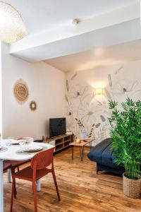 salon z łóżkiem i stołem w obiekcie Cocon Marguerite - Appartement cosy - Idéal pro et cyclistes w mieście Mayenne