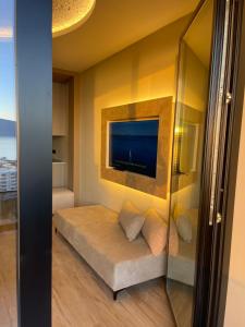 a living room with a couch and a flat screen tv at Seamare Studio & Apartaments in Vlorë