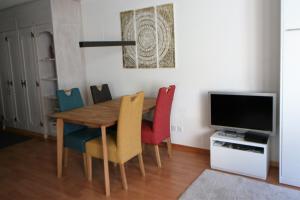 シュクオルにあるTulai 104Eのダイニングルームテーブル(カラフルな椅子付)、テレビが備わります。