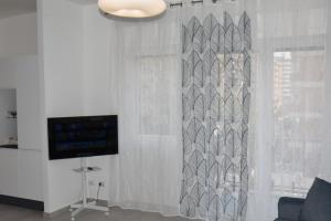 a living room with a curtain and a television at SWEET RETREAT - Trastevere Station in Rome