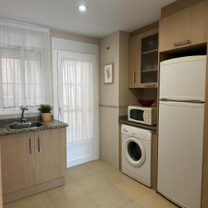a kitchen with a white refrigerator and a microwave at Torremar Living in Oropesa del Mar