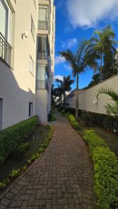 a brick walkway next to a building with a palm tree at Apto Ipiranga 1 Quarto com vaga de garagem in Sao Paulo +51 photos
