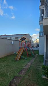 a set of wooden play structures sitting on the grass at Apto Ipiranga 1 Quarto com vaga de garagem in Sao Paulo