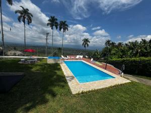 a swimming pool in a yard with palm trees at Villa Pacola in Pueblo Tapao