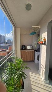 a kitchen with a balcony with a view of a city at Apto Ipiranga 1 Quarto com vaga de garagem in Sao Paulo
