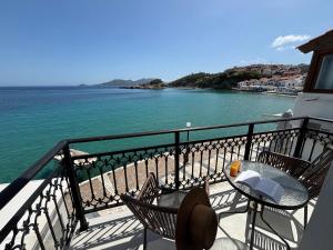 a balcony with a table and chairs and the ocean at Galaris' Luxury Room in Kokkari