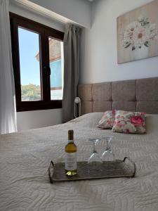 a tray with a bottle of wine and two glasses on a bed at Galaris' Luxury Room in Kokkari +12 photos