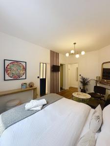 una camera con un grande letto bianco e un soggiorno di So Guest, Clou dans le fer, modern suite near cathedral a Reims Altre 21 foto