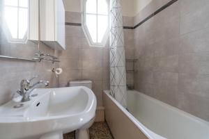 ein weißes Badezimmer mit Waschbecken und Badewanne in der Unterkunft Villa Maurel YourHostHelper in Arles