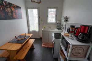 a kitchen with a wooden table and a counter top at fleur de sel d Oléron 3 chambres in Le Château-dʼOléron