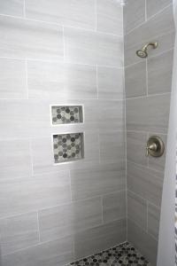 a bathroom with a shower with gray tiles at 3 Bedroom Lake House With Garage in Tallahassee