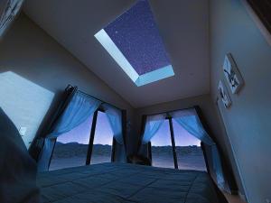 a bedroom with a bed and a large window at Grand Canyon Stargazing Off-Grid in Williams