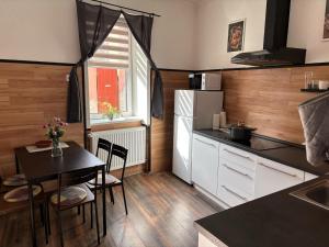 a kitchen with a table and a dining room at Mázli Vendégház in Sátoraljaújhely