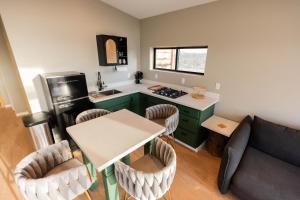 Il comprend une cuisine avec une table et un canapé. dans l'établissement Grand Canyon Stargazing Off-Grid, à Williams 22 autres photos