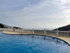 a large swimming pool with a fence and water at Private Room Shared Apartment Sea View Pool Marbella Mijas in Sitio de Calahonda +84 photos