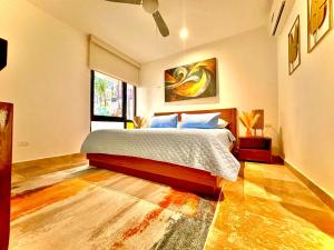 a bedroom with a bed and a painting on the wall at Caribbean soul in Tulum +12 photos