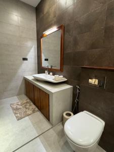 a bathroom with a toilet and a sink and a mirror at Lady Lavinia Residence in Mount Lavinia +15 photos