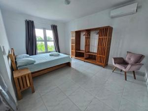 a bedroom with a bed and a chair and a window at Pousada Aryanne in Pecém +29 photos