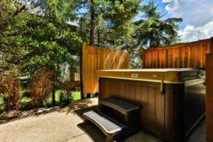 a barbecue grill in a backyard next to a fence at Dog friendly Home on Ski Hill with Hot Tub by StayIn in Fernie