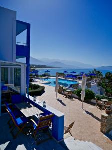 een patio met stoelen en parasols naast een zwembad bij Kanakis Blue Beach Apartments in Petres
