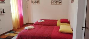 a room with two beds with red and yellow sheets at A casa di Rita in Dunarobba