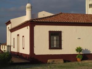 ein weißes und rotes Gebäude mit einem Fenster in der Unterkunft Monte dos Alpendres I Farmhouse in Serpa