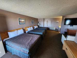a hotel room with two beds and a flat screen tv at Satellite Inn in Alamogordo