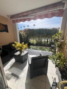 a patio with a table and chairs and a view of a vineyard at 2P jardin Sud vue Lac avec piscine tennis parking privé in Le Cannet