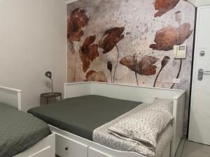 a bedroom with a bed and a wall with leaves at Casa Noè - cozy home with big terrace and private box in Turin +19 photos