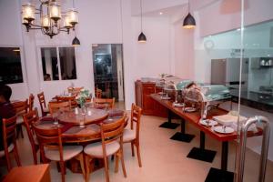 une salle à manger avec une table et des chaises en bois dans l'établissement Hillwood Resort & Restaurant, à Hewaheta