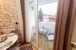 a room with a balcony with a table and a glass door at Apartman MERY centar Novi Pazar in Novi Pazar +14 photos