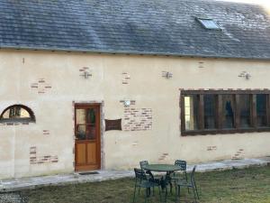 a table and chairs in front of a building at Les Alpagas de La Tuilerie , 3 Chemin de la Tuilerie in Batilly-en-Puisaye