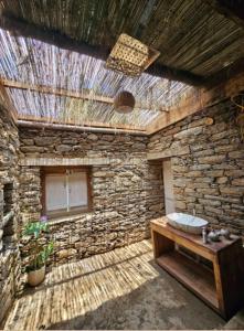 Un baño de piedra con lavabo y pared de piedra. en Chaukhamba Cradle, en Ukhimath