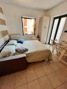 una camera da letto con un letto, un tavolo e finestre di Il rifugio urbano a Chivasso