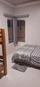 a bed in a room with two windows at Casa completa com 2 quartos, área gourmet e piscina in Macapá +34 photos