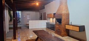 a kitchen with a brick fireplace in a room at Casa completa com 2 quartos, área gourmet e piscina in Macapá