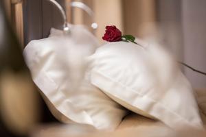 una rosa roja sentada encima de una almohada blanca en La Maison D'Art en Santa Teresa Gallura