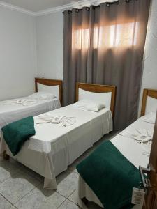 due letti uno accanto all'altro in una stanza di Oriente Hotel Outlet a Campo Novo do Parecis