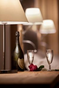 聖特雷莎加盧拉的住宿－La Maison D'Art，一瓶香槟和一张桌子上的两杯酒