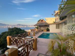 a house with a swimming pool and a view of the water at Villa de descanso in Acapulco