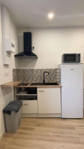 a kitchen with a white refrigerator and a microwave at Studio Cosy - proche du centre ville in Guingamp +5 photos