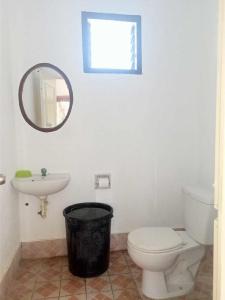 a bathroom with a toilet and a sink and a mirror at Villa Rosita in Dauin